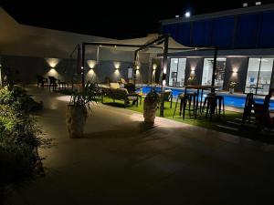 a patio at night with chairs and a table at The New Chalet in Sowayma