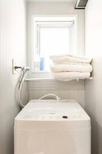baño blanco con lavabo y ventana en #803 Opening sale! Private rental Osaka city central Has the longest shopping street and you can enjoy the real Osaka, which has not yet become a tourist destination, en Osaka