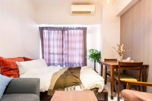 sala de estar con sofá y mesa en #803 Opening sale! Private rental Osaka city central Has the longest shopping street and you can enjoy the real Osaka, which has not yet become a tourist destination, en Osaka