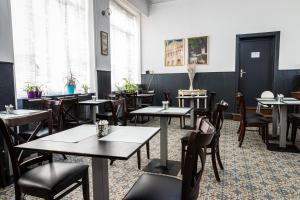 a dining room with tables and chairs and windows at Hotel Du Dauphiné in Lyon