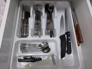 a white tray with utensils in a drawer at Sanny Bay in Qiryat Yam
