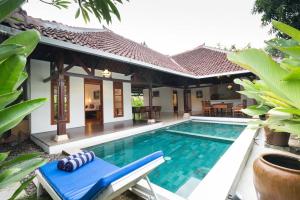 a villa with a swimming pool and a house at Royal Indah Bali Villas in Seminyak