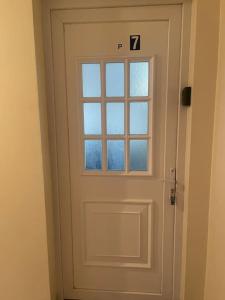 Una puerta blanca con una ventana en una habitación en L7/ Villiers-le-Bel proche Roissy & Paris en Villiers-le-Bel