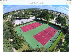 an overhead view of two tennis courts with trees at Mickey Holiday Home a Windsor Palms Villa in Kissimmee +25 photos