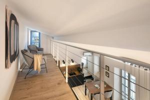Una habitación con una escalera con un sofá y una silla. en Apartments Ginger & Blue in a charming historic town, en Labin