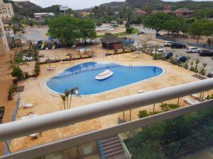 vista para uma piscina num parque de estacionamento em Sunny place. em Guardamar del Segura