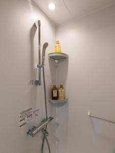 a bathroom with a shower with two bottles on a shelf at 殿堂 in Tokyo
