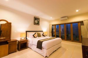 a bedroom with a bed and a large window at Royal Indah Bali Villas in Seminyak