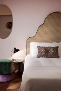 - une chambre avec un lit, une chaise et un miroir dans l'établissement Agora' - Boutique Stays, à Turin