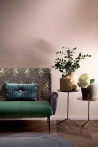 un salon avec un canapé et deux plantes en pot dans l'établissement Agora' - Boutique Stays, à Turin