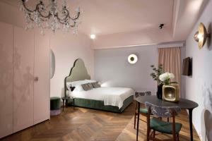 une chambre d'hôtel avec un lit, une table et des chaises dans l'établissement Agora' - Boutique Stays, à Turin