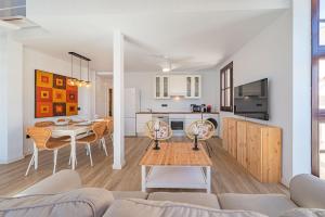 ein Wohnzimmer und eine Küche mit einem Sofa und einem Tisch in der Unterkunft Doña Elvira. Las Terrazas in Málaga