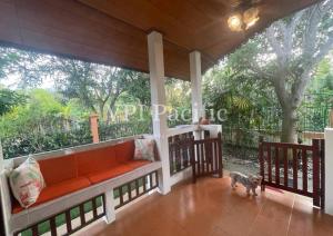 a porch with an orange couch and a dog on it at Jacuzzi Pool Villa Isabelle 1bed in Nathon Bay
