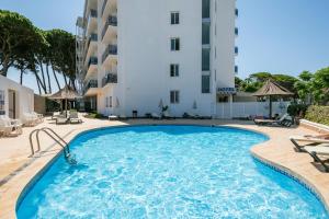 a swimming pool in front of a hotel at Hotel Best Terramarina in La Pineda