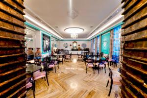 a dining room with tables and chairs and a wall at Palacete de la Ochava in Valdilecha