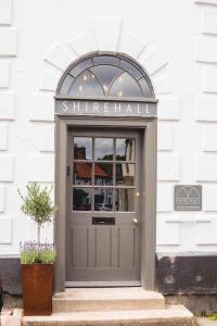 Shirehall Apartments في هولت: باب رمادي للمبنى مع وجود علامة عليه