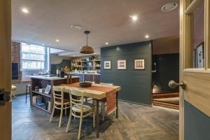 cocina con mesa, sillas y barra en Shirehall Apartments, en Holt