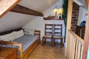 ein Schlafzimmer mit einem Sofa und einem Stuhl im Dachgeschoss in der Unterkunft Gite les Pommettes in Étretat