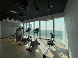 um ginásio com equipamento cardiovascular numa sala com janelas em LUXE 2BR at 1 RESIDENCES WASL NEAR METRO STATION em Dubai