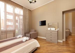 a bedroom with a bed and a dresser and a mirror at HD Dream Apartment in Tbilisi City