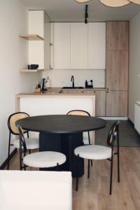 cocina con mesa, sillas y fregadero en Apartamenty Centrum, en Krotoszyn