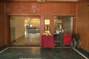 een eetkamer met een tafel en een rode stoel bij Kings Hotel Egmore in Chennai