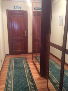 korytarz z dwoma lustrami, drzwiami i dywanem w obiekcie Apartamento en la Playa de Somo. w mieście Somo