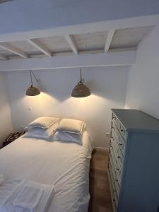 - une chambre avec un lit, deux lumières et une commode dans l'établissement Les maisons du Salvignol, 