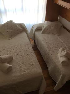 two beds in a room with towels on them at Apartamento en la Playa de Somo. in Somo