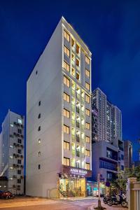 峴港的住宿－Anh Đào Hotel & Apartment，一座高大的白色建筑,灯火通明