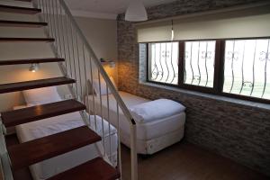 a room with a staircase with a bed and a window at Aqua Boss Hotel in Eceabat