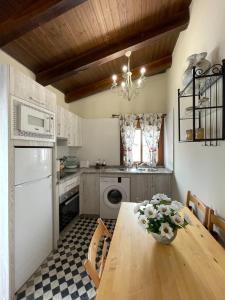 una cocina con una mesa de madera con un jarrón de flores. en Casa rural 3R, en Don Álvaro