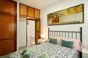 Schlafzimmer mit einem Bett und einem Wandspiegel in der Unterkunft Apartamento Danoe 1 in Mogán