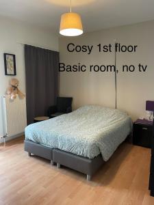 1 dormitorio con 1 cama con un cartel en la pared en Casa Christel en Mechelen