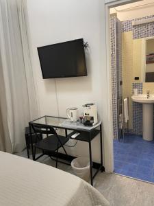 a bedroom with a table and a bathroom with a sink at Grillo in Salerno
