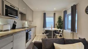 cocina y sala de estar con sofá y mesa en The Windsor Lodge, en Brighton & Hove