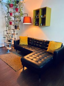 a black leather couch in a living room at City Garden Apartments in Bucharest