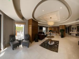 ein Wohnzimmer mit Sofa, Tisch und Stühlen in der Unterkunft Celino Hotel in Amman