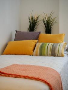 a bed with yellow and orange pillows and plants at Apartamento en Bilbao in Bilbao