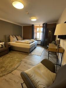um quarto com uma cama, um sofá e uma cadeira em Hotel Sleep and Eat em Hardegsen