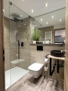 uma casa de banho com um WC e uma cabina de duche em vidro. em Hotel Sleep and Eat em Hardegsen