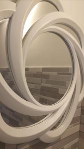 a group of white spiralling mirrors on a wall at Il CASALETTO di Laura in Fiumicino
