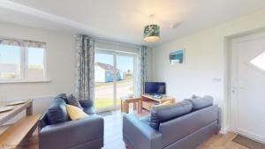 a living room with two couches and a television at G07 Tweenbanx, Riviere Towans in Hayle