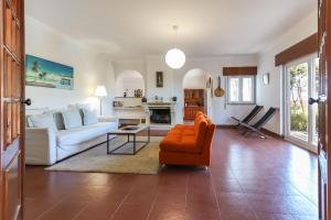 a living room with an orange chair and a couch at Sintra Classic Villa with Pool by Homing in Sintra