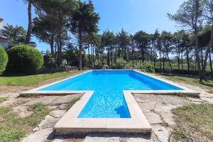 a swimming pool with blue water in a yard at Sintra Classic Villa with Pool by Homing in Sintra