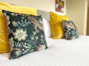 uma cama com uma almofada preta e almofadas amarelas em 2-Bed Victorian Elegance em Chester