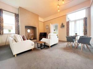 uma sala de estar com dois sofás brancos e uma mesa em 2-Bed Victorian Elegance em Chester