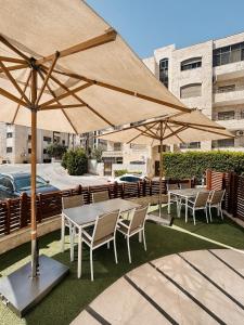 a group of tables and chairs with umbrellas at Celino Hotel in Amman