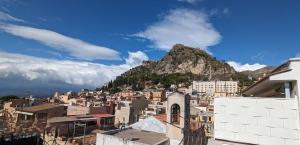 uitzicht op een stad met een berg op de achtergrond bij Opuntia Charming Rooms in Taormina