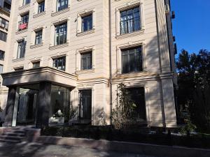 a large white building with many windows at Centrado Apartments in Tashkent